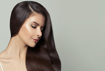A woman shows her long-lasting hair extensions in The Woodlands at Hair Extensions of Houston.